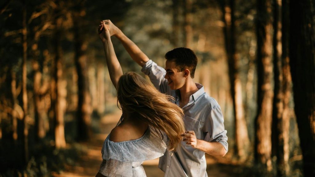 A couple dancing in a forest.