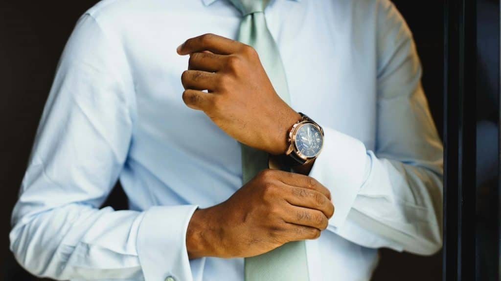 A man adjusting a watch with elegant attire.