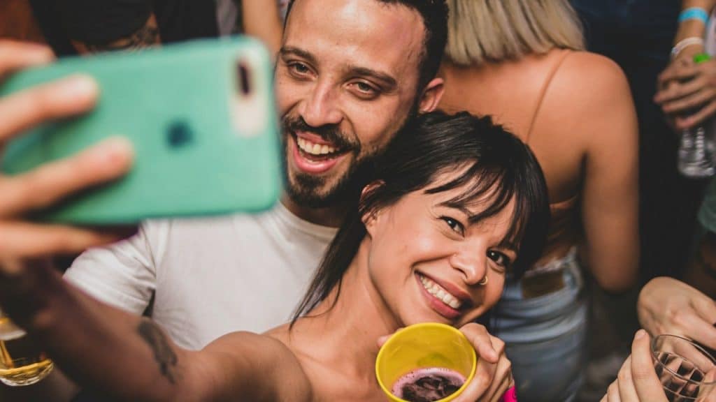 A man and woman holding yellow ceramic mugs.