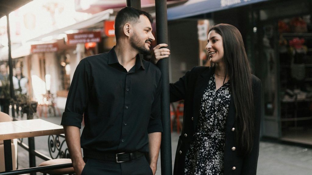 A couple gazes affectionately at each other outdoors.