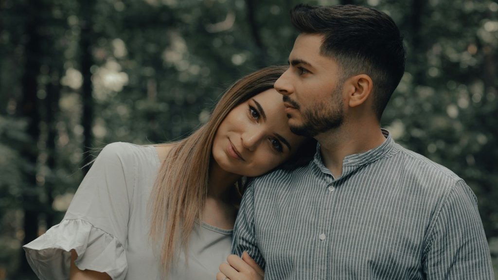 A woman leaning her head on a man's shoulder.