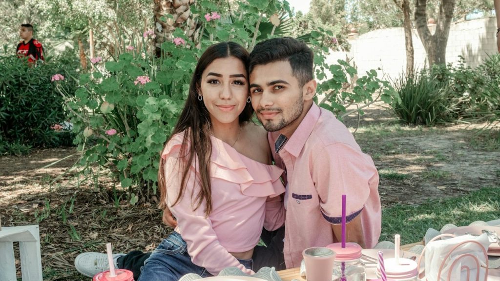 A couple sitting outside at a picnic table.