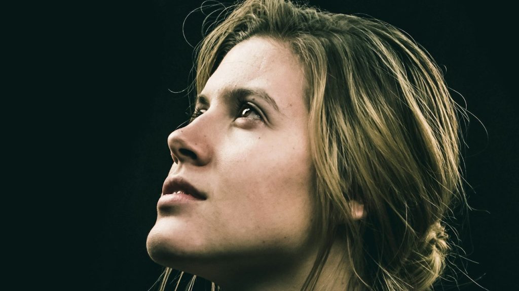 A blonde woman looking upward.