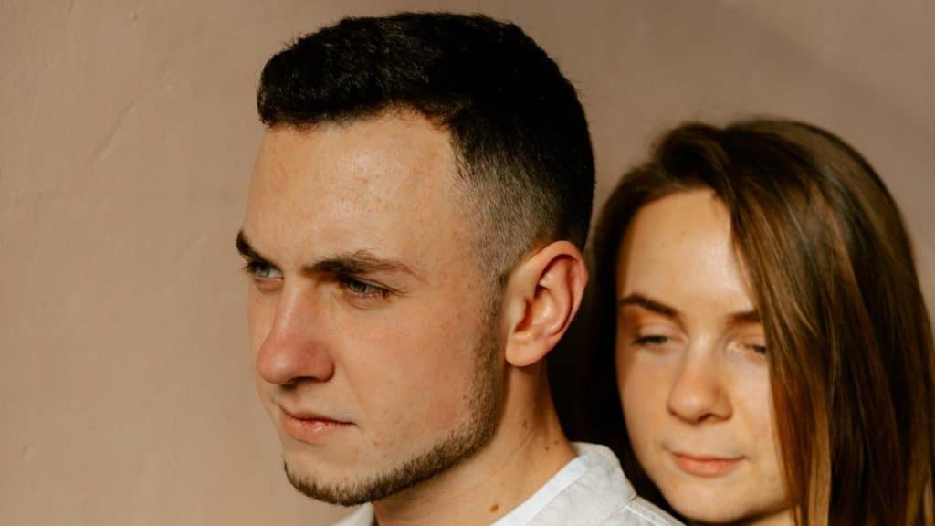 A man looking away from the woman standing beside him.