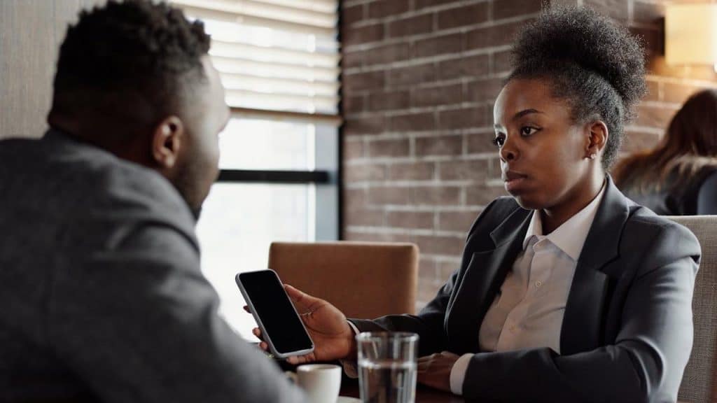 A rude showing something on her phone to her boyfriend.