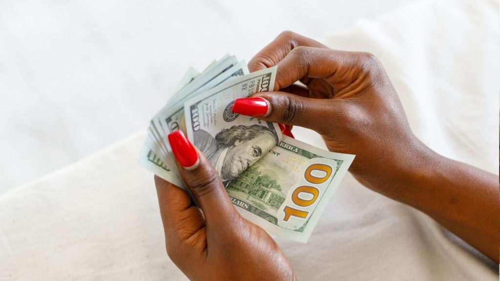 A woman holding a stack of money in her hands.