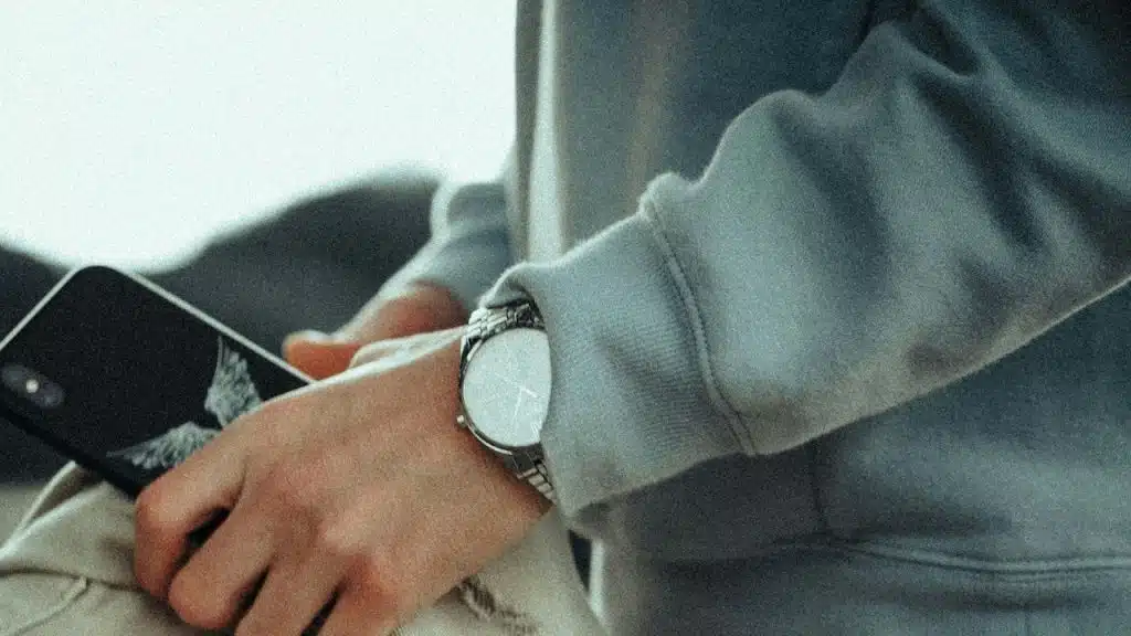 A person holding a jacket and a cell phone.