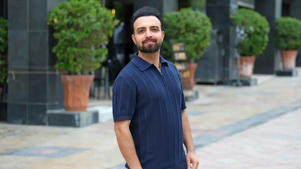 A man in a navy polo shirt standing outside.