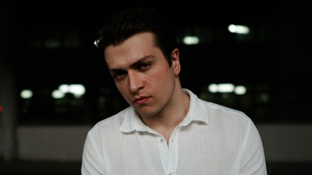 A man in a white shirt is sitting down.