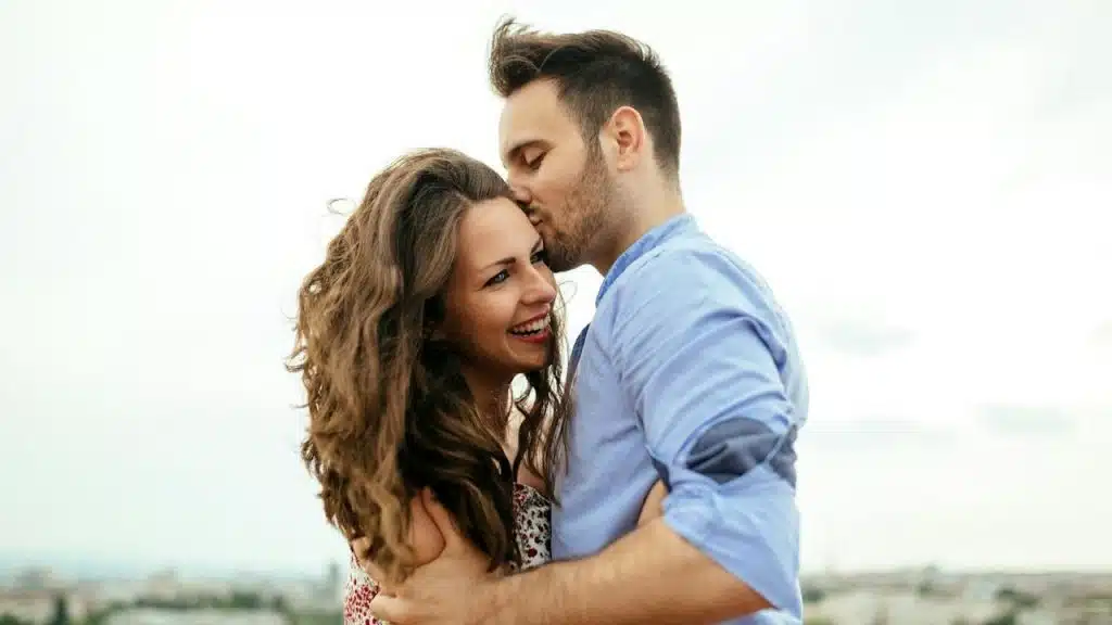 A couple hugging each other outdoors.