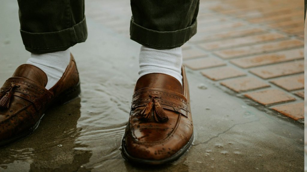 A person in brown leather shoes.