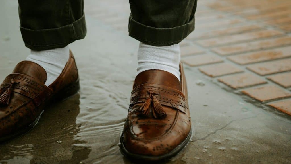 A person in brown leather shoes.
