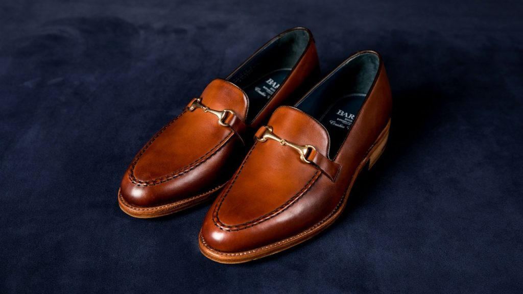 Brown leather loafers on blue textile.