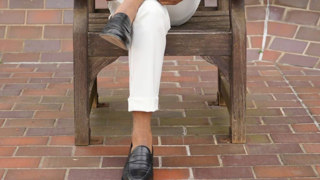 A man sitting in a chair with his legs crossed.