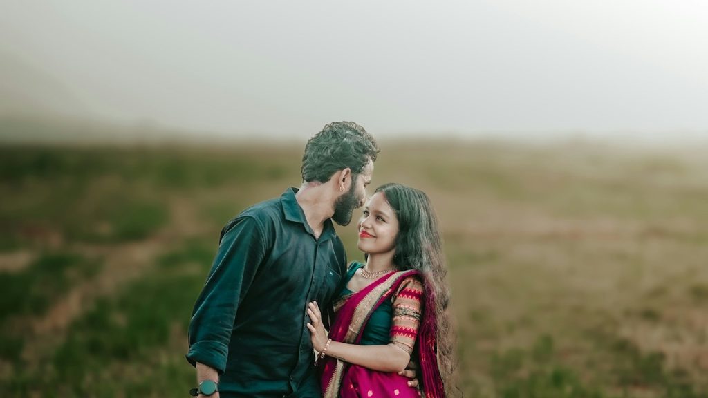 A man and a woman are standing in a field.