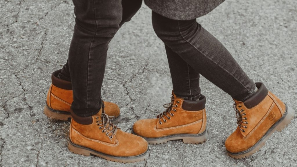 Two people standing next to each other wearing brown shoes.