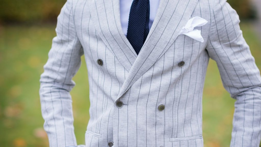 A man in a white-and-black, pinstripe, double breasted suit.