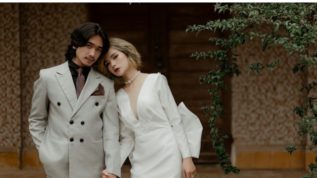 A couple in informal attire holding hands outdoors.