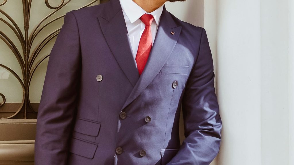 A man in a blue suit holding a newspaper.
