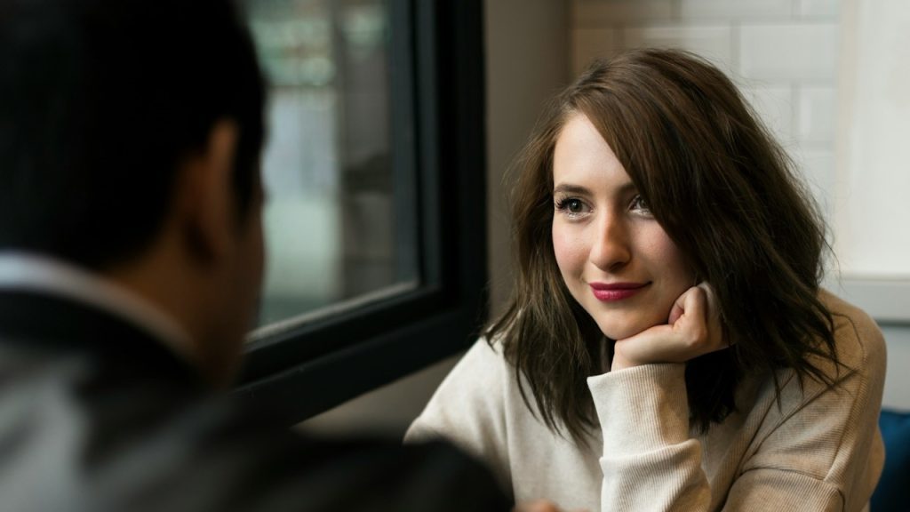 A woman looking at her partner while sitting at a table together.