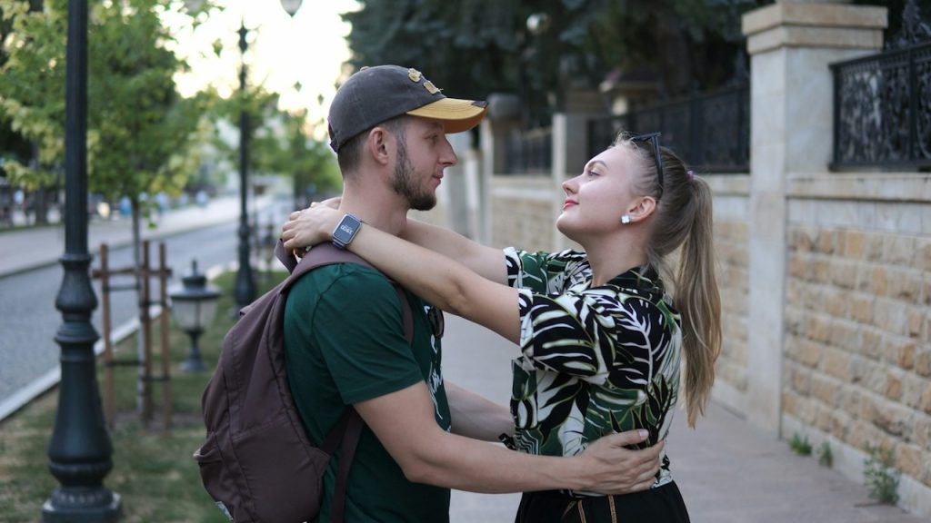 A man standing next to a woman on a sidewalk.