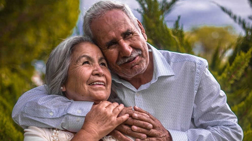 A man in a white dress shirt is hugging a woman in a white dress.