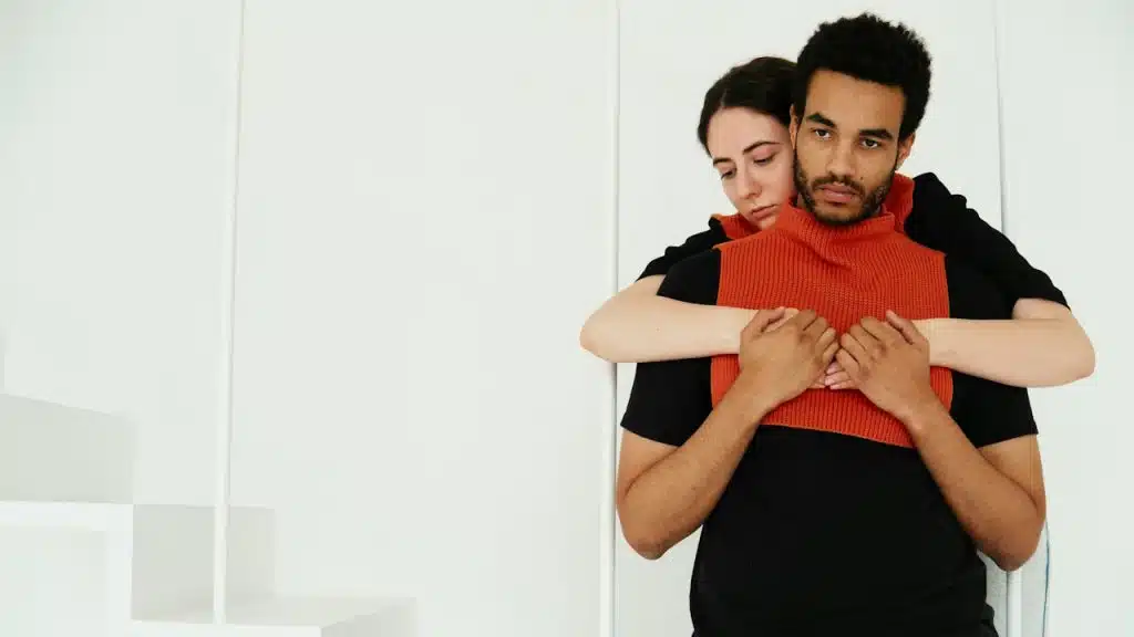 A woman hugging a man from behind.
