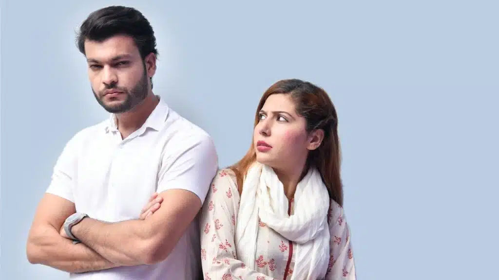 A woman looking at her man who is being rude with her.