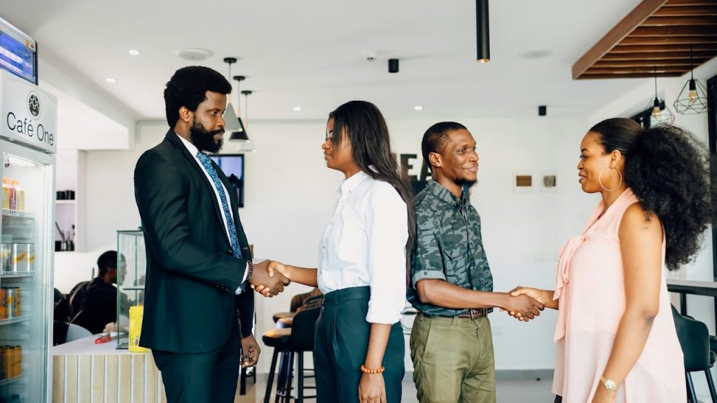 People shaking hands with each other in an office.