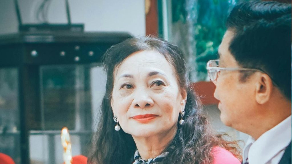 An elderly couple is sitting in a family gathering.