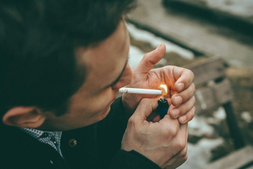 Man lighting up a cigarette.