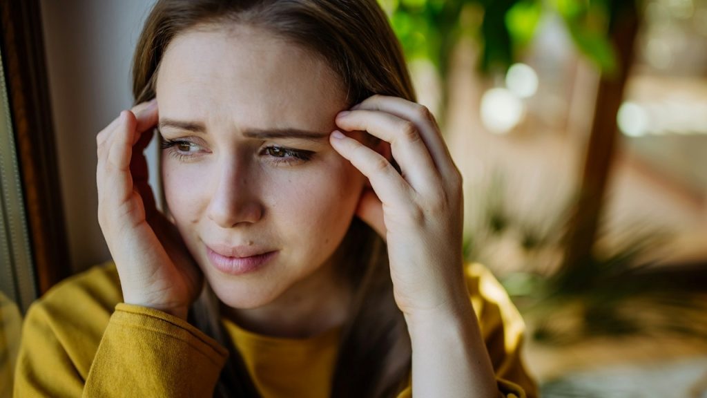 A woman suffering from depression crying at home.