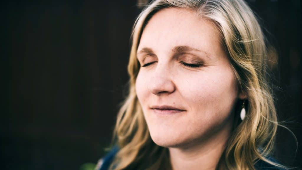 A mature woman with her eyes closed.