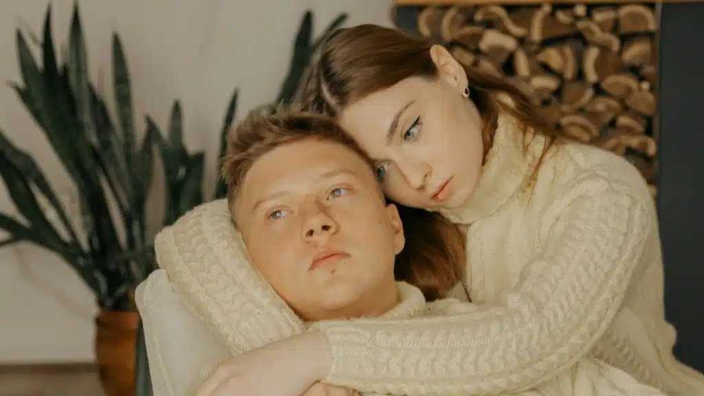 A man and a woman lying on a couch.