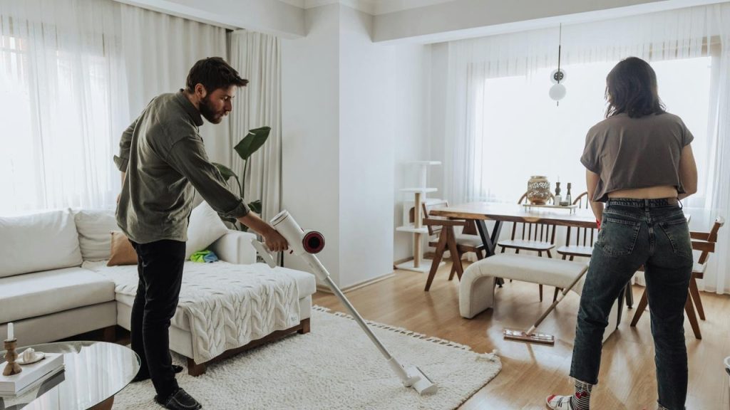 A couple cleaning the living room together.