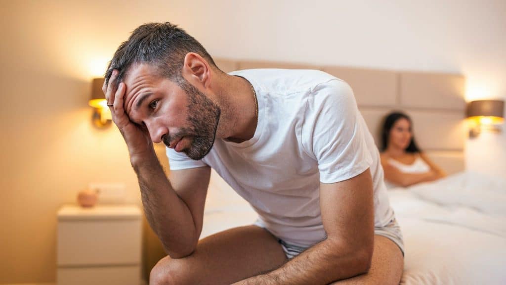 A man thinking and a woman sitting on the bed