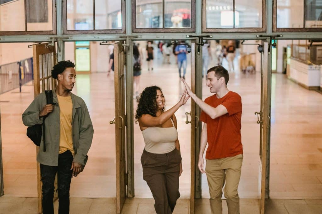 Woman introducing man to friends, man standing off to the side