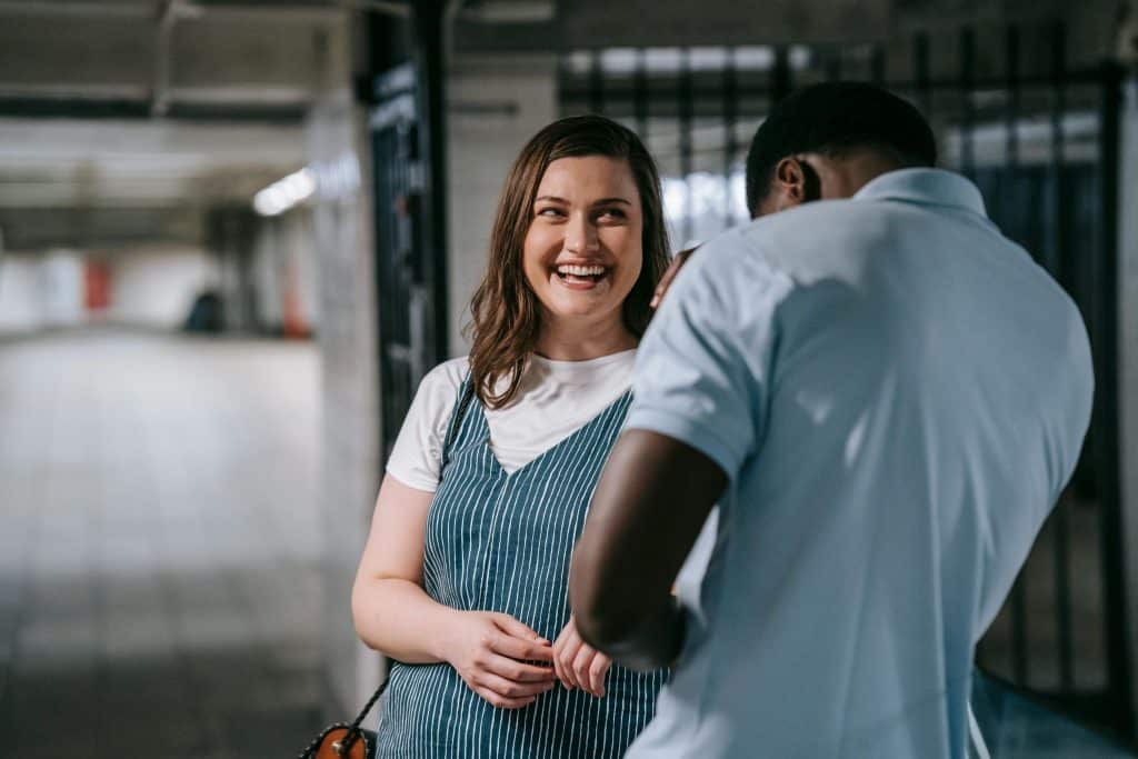 Woman smiling at man, man ignoring her