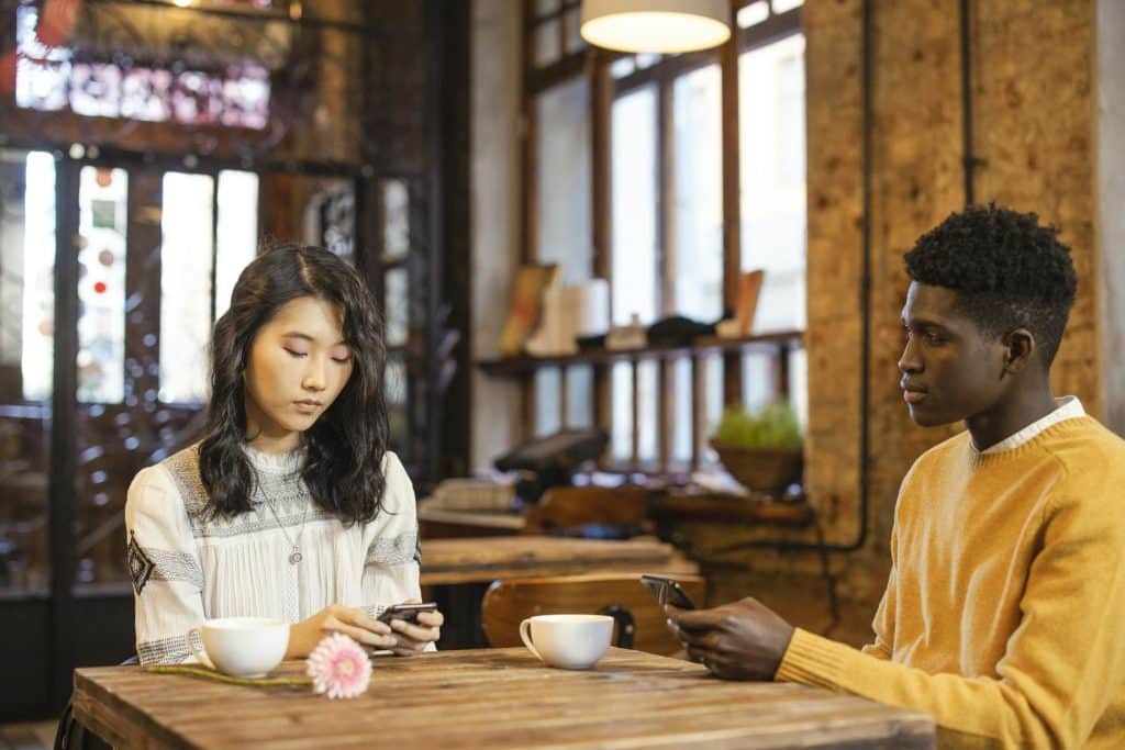 Woman canceling plans while man looks disappointed