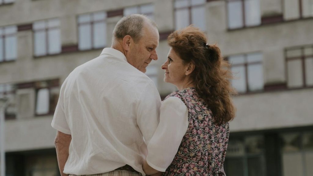 A man and a woman standing next to each other in front of a building.