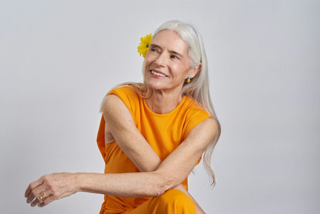A woman with a yellow flower in her hair.