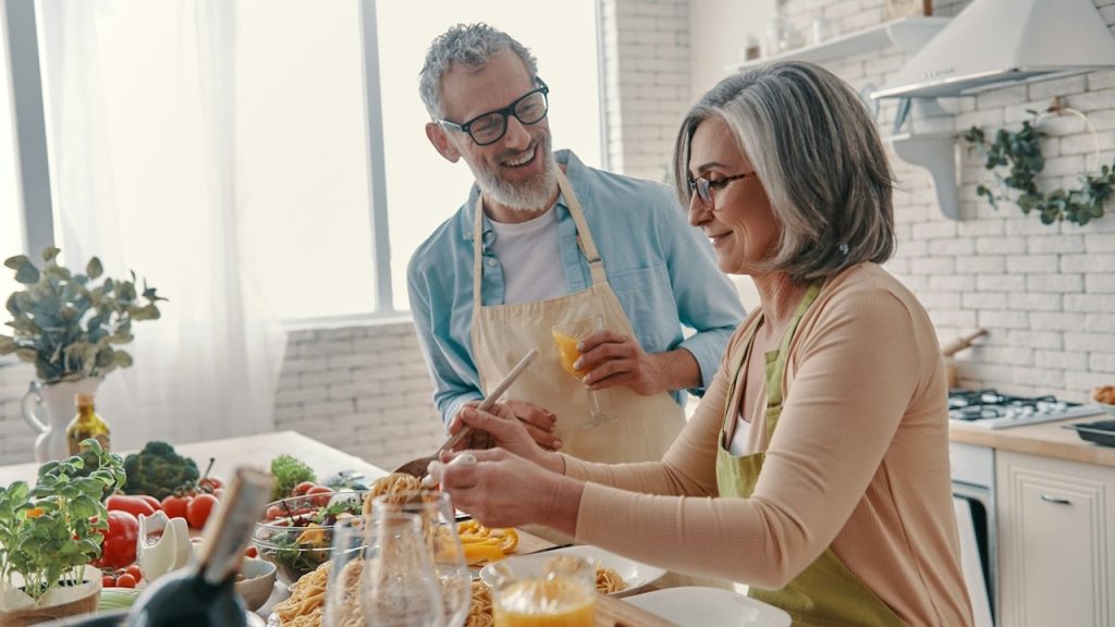 A couple cooking together in the kitchen.