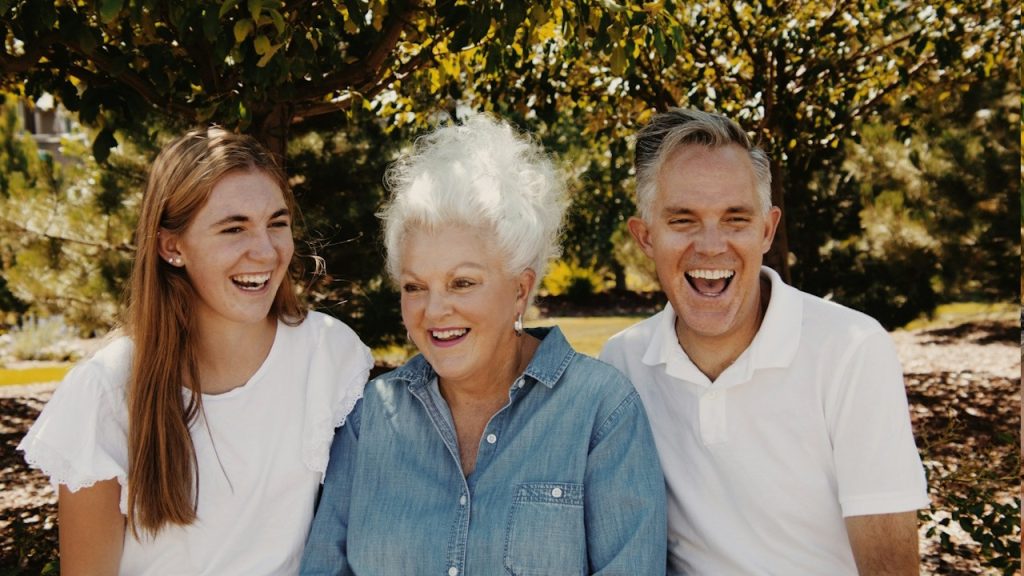A family laughing together while sitting in a park.