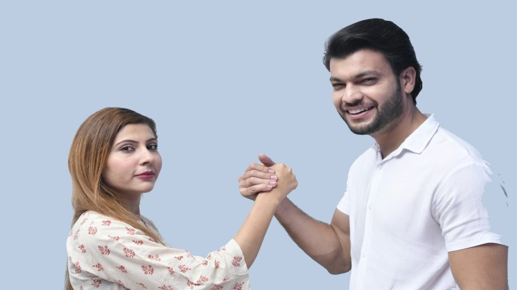 A man and woman posing for a picture while holding hands.