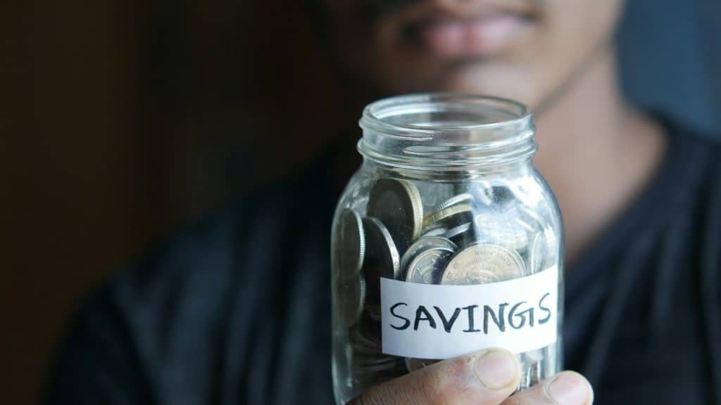 A man Holding a jar fulled with coins