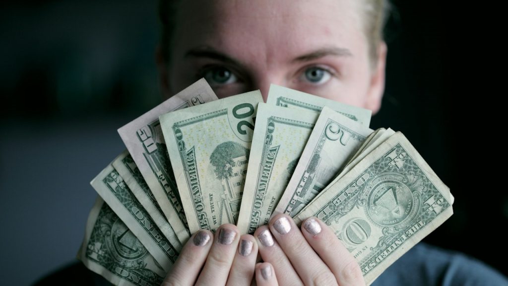 A woman holding dollars in her hands.