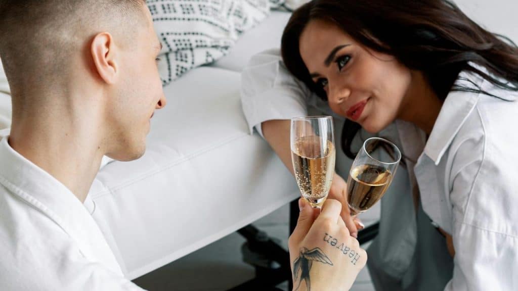 A couple relaxing indoors while toasting with champagne glasses