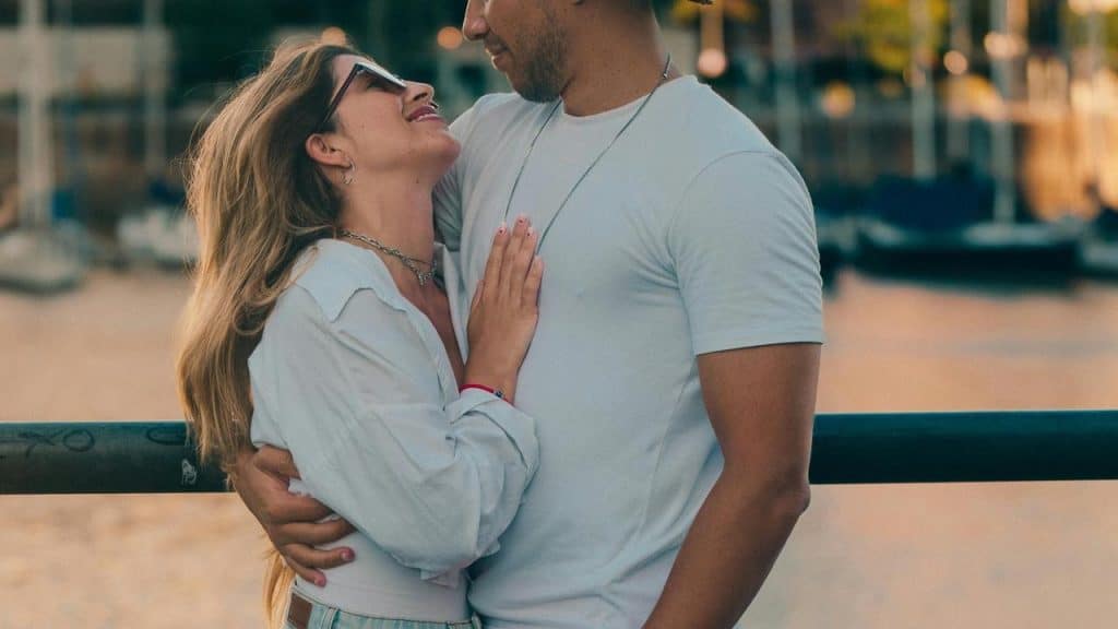 A couple embracing and smiling at each other outdoors