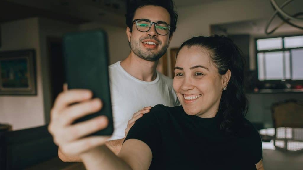 A smiling couple taking a selfie indoors
