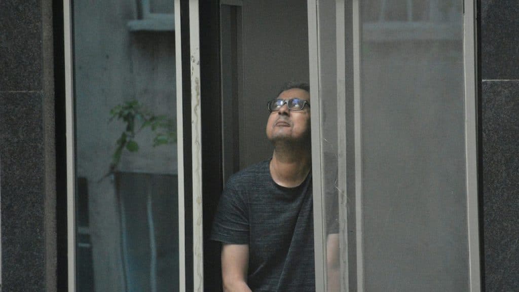 A man looking out of a window in a building.